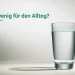 Wasserglas fast bis zur markierten Grenzlinie gefüllt, eine leuchtende Linie zeigt den kritischen Füllstand.