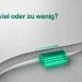 Ein Maßband umschließt einen leuchtenden Stapel durchscheinender Datenkarten exakt an seinem Mittelpunkt auf grauer Steinfläche.