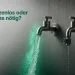 Zwei nebeneinander montierte Wasserhähne an Betonwand: links voller freier Strahl mit grünem Lichtschimmer, rechts gedrosseltes Rinnsal.